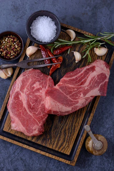 Zwei rohe Striploin-Steaks, Knoblauch, Pfeffer und Rosmarin — Stockfoto