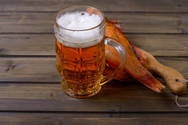 Tazza di birra e pesce affumicato sul tavolo di legno — Foto Stock