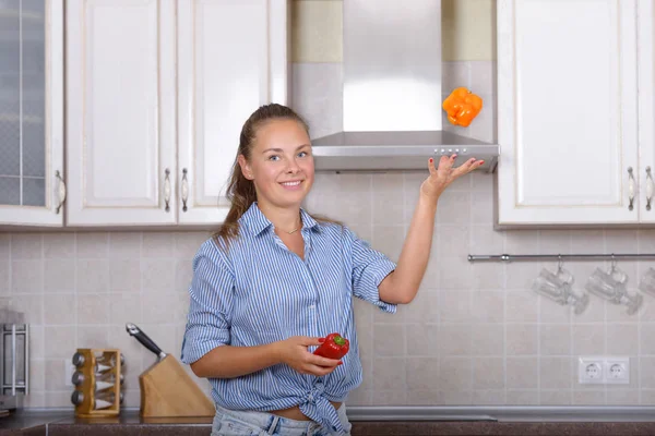 Kız kırmızı dolmalık biber juggles — Stok fotoğraf