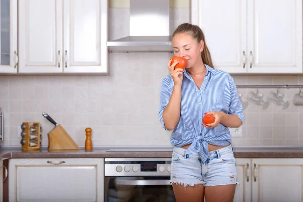 Девушка наслаждается запахом свежих помидоров — стоковое фото