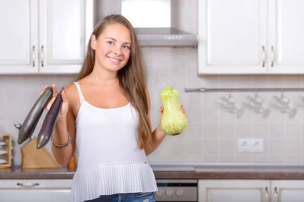 Счастливая женщина держит в руках овощные баклажаны и сквош — стоковое фото