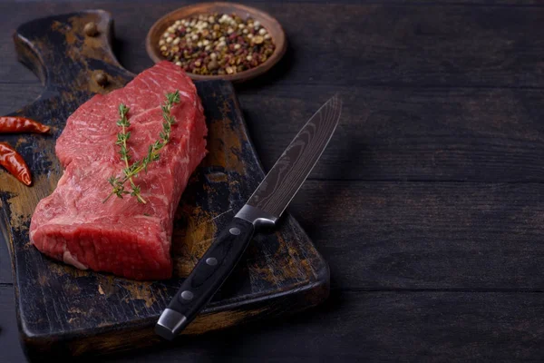 Bife de carne com tomilho e pimenta e faca — Fotografia de Stock