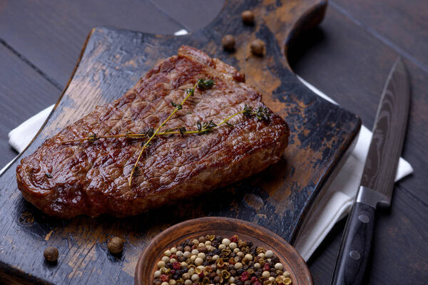 Closeup grilled steak on cutting board on wooden background
