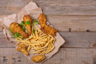 Çıtır tavuk et ve patates kızartması ahşap arka plan üzerinde