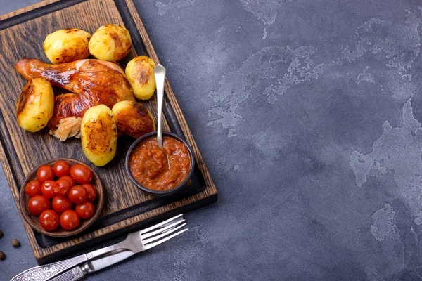 Fried chicken and potato with sauce and tomatoes — Stock Photo, Image