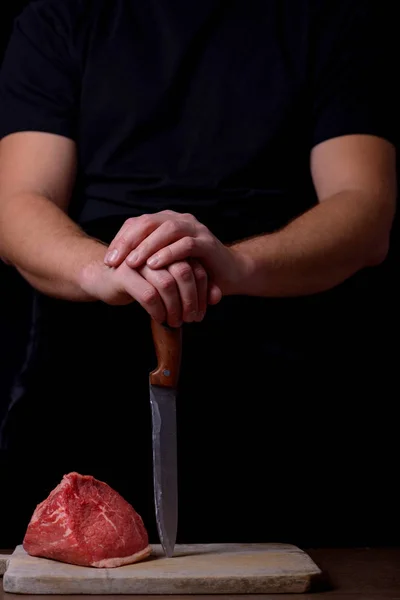 Açougueiro com faca e carne crua — Fotografia de Stock
