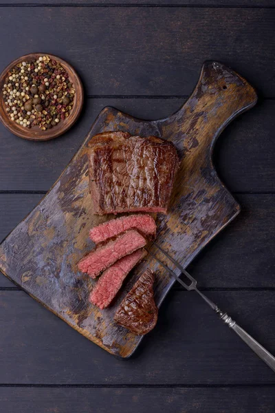 Mittelseltenes Steak auf Schneidebrett — Stockfoto