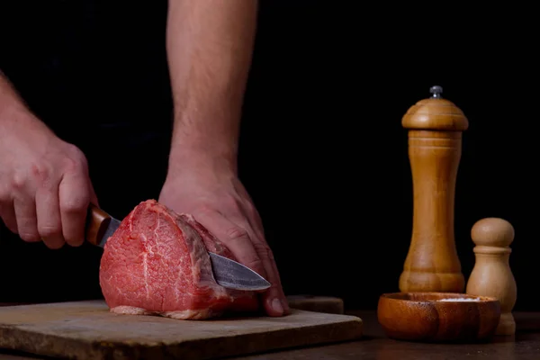 Uomo taglio carne di manzo in cucina — Foto Stock