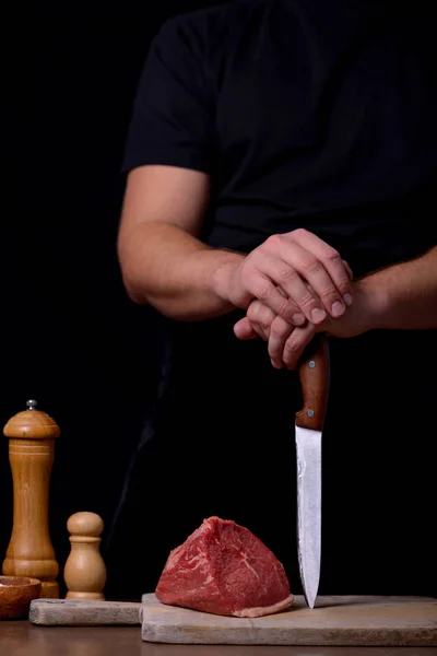 Mãos homem com faca e carne crua — Fotografia de Stock