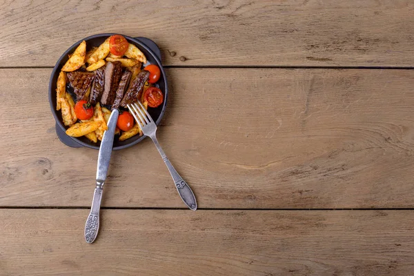 Нарезанная говядина с картошкой и помидорами — стоковое фото