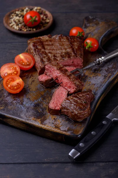 Filete en rodajas y tomates en tabla de cortar — Foto de Stock