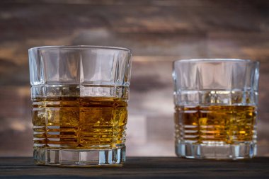 Ahşap arka planda iki bardak altın viski. Viski ya da brendi.