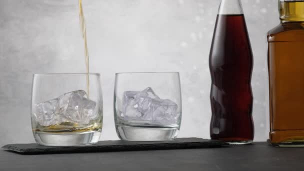 Nalít Whisky Sklenici Kostkami Ledu Pozadí Dvě Láhve Kolou Alkoholem — Stock video