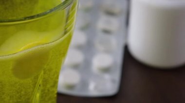 Arka plandaki tıbbi tabletin camında C vitamini var.