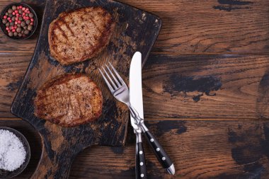 Ahşap masada ızgara biftek ve fotokopi alanı.
