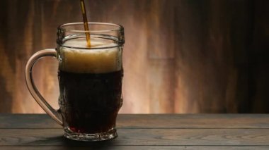 Koyu bira, ahşap zemin üzerine cam dökerek fotokopi alanı oluşturuyor.