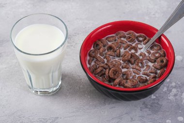 Çikolatalı organik kahvaltı gevrekleri ve masada sütlü bardaklar. Çocuklar için sağlıklı yemek