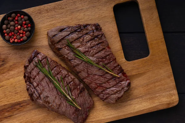 Zwei Gegrillte Rindersteaks Mit Gewürzen Und Rosmarin Auf Dem Schneidebrett — Stockfoto