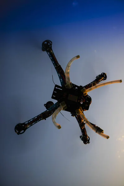 Quadrocopter in flight at sunset — Stock Photo, Image