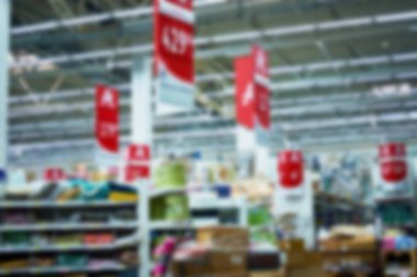 Işığın ve modern süpermarketin içinde yürüyen insanların odaksız fotoğrafı. Arkaplan olarak reklam, sunum ve hareket tasarımı için kullanılabilir