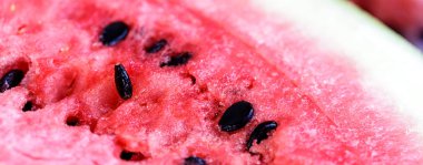 Büyütülmüş makro shot ile kırmızı dilimlenmiş karpuz ve ahşap masaya yakın çekim. Arkaplan