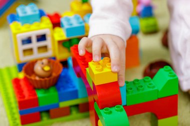 Çocuklar ellerinde çocuk eli olan plastik tuğlalar. Kapat.