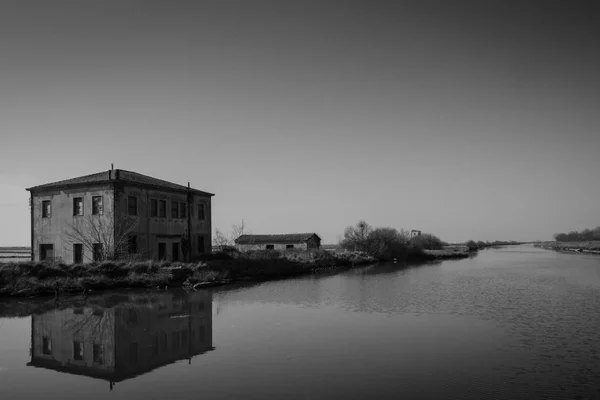 Construcción de la antigua Salina di Comacchio vista desde el Canal Logonovo, un estanque de evaporación de sal es una sartén artificial poco profunda diseñada para extraer sales del agua del mar u otras salinas. —  Fotos de Stock