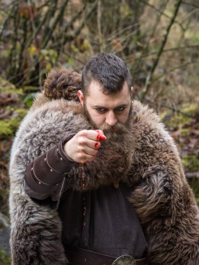 eski bir Viking savaşçısı kanlı elini yumruk clenches