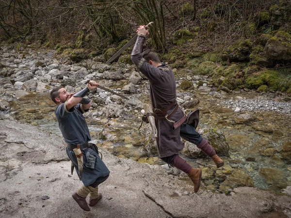 Two Viking warriors fight with the sword on the bank of the rive — Stock Photo, Image