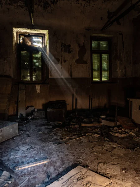 Promienie światła przenikają przez okno opuszczonego pokoju. — Zdjęcie stockowe