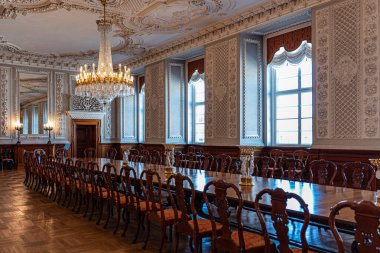 Kopenhag, Danimarka 'daki Christiansborg Sarayı' ndaki kraliyet salonlarının içi, büyük antika masa ve kristal avize.