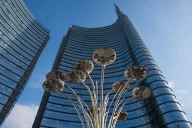 Mavi gökyüzünü yansıtan vitray pencereli gökdelenlerin alt görüntüsü, çağdaş mimarinin görüntüsü