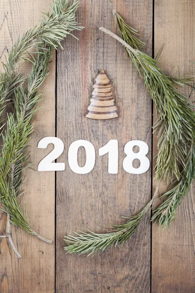 Nápis roku 2018 na dřevěný stůl s prvky z větve vánočního stromku — Stock fotografie