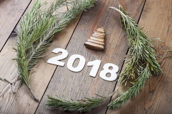 Inscription 2018 on a wooden table with elements of Christmas tree branches — Stock Photo, Image