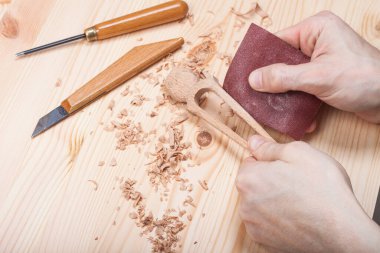 Usta, geleneksel zanaatkar ahşaptan aksesuarlar yontuyor.