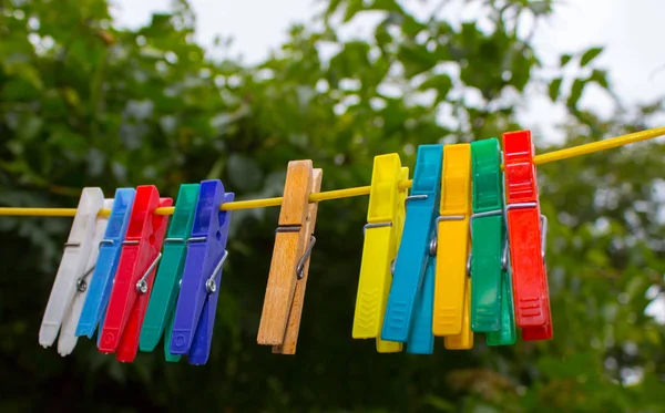 Mollette di plastica appese a una clothesline — Foto Stock