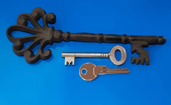 Старые и новые ключи на синем фоне — стоковое фото