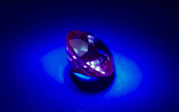 Pink sapphire on a blue background in light — Stock Photo, Image