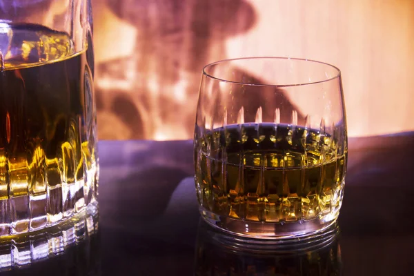 Carafe and glass with whisky on a fiery background — Stock Photo, Image