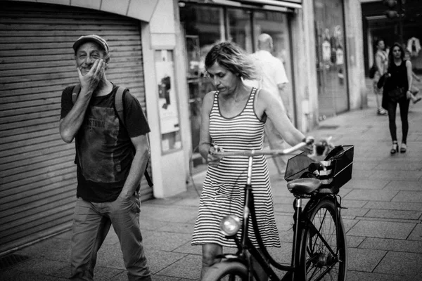 Mujer caminando en la acera con bicicleta en las manos —  Fotos de Stock