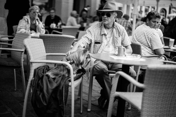 Ludzie siedzący w ulicznej kawiarni — Zdjęcie stockowe
