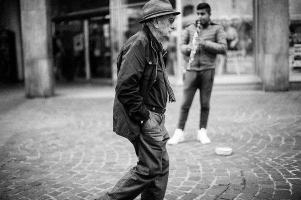 Hombre caminando cerca de músico —  Fotos de Stock