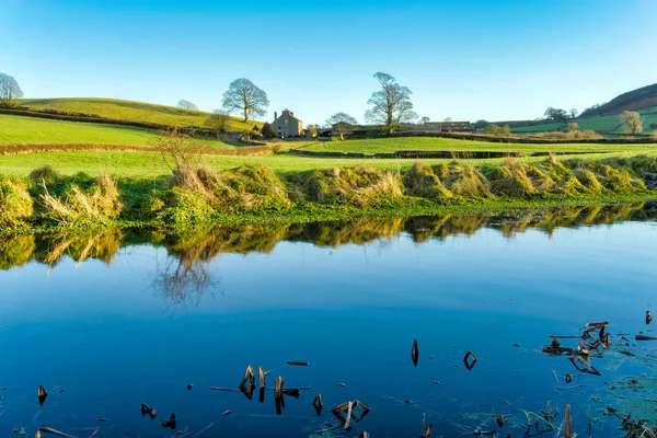 Blick auf den Lancasterkanal mit einem Bauernhaus, das von zwei Bäumen gesäumt wird — Stockfoto