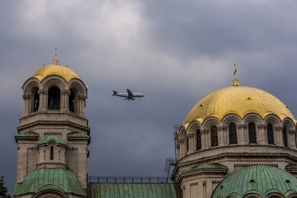 dramatik bir gökyüzü arka planı bir kilise kubbeleri arasında bir uçak uçar. kentsel peyzaj ve küçük bir uçak ile büyük bir kilise.