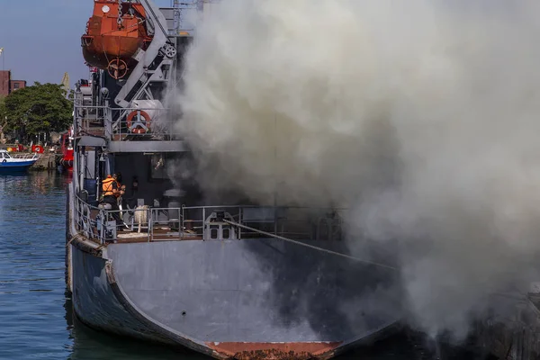 fire on a ship. the crew quenched the fire during the military scientists at the port. disaster on a vessel and struggle for life.