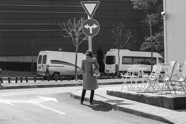 bir yol işareti önünde duran ve merak kadın nereye gitmek. Nereye gideceğimi seçme. ikilem yakalamak için hangi yol.
