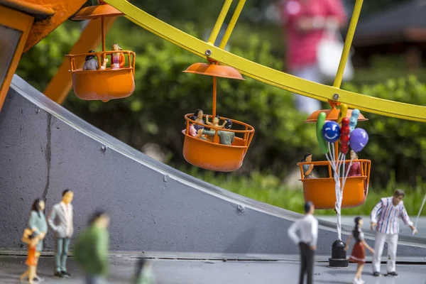 Minyatür karnaval ve dönme dolap. minyatür erkekler renkli renklerde boyanmış. Diorama.
