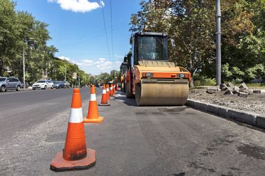 Turuncu yol konileri ağır tekerlek Kompaktörler şehir sokak yol kenarı boyunca korumak