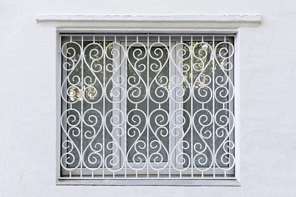 Moldura figurada da janela com ferro forjado grade branca — Fotografia de Stock
