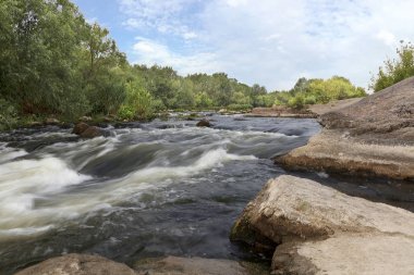 Yaz - kayalık sahilleri, rapids, hızlı Nehri akış, parlak yeşil bitki örtüsü ve bulutlu bir mavi gökyüzü güney Bug Nehri